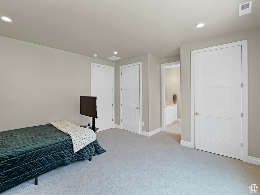 Bedroom featuring light carpet, recessed lighting, baseboards, and connected bathroom