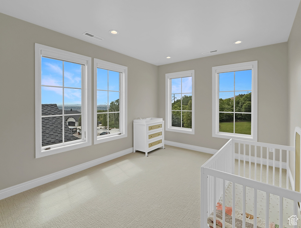 Unfurnished bedroom with baseboards, carpet flooring, recessed lighting, and a nursery area