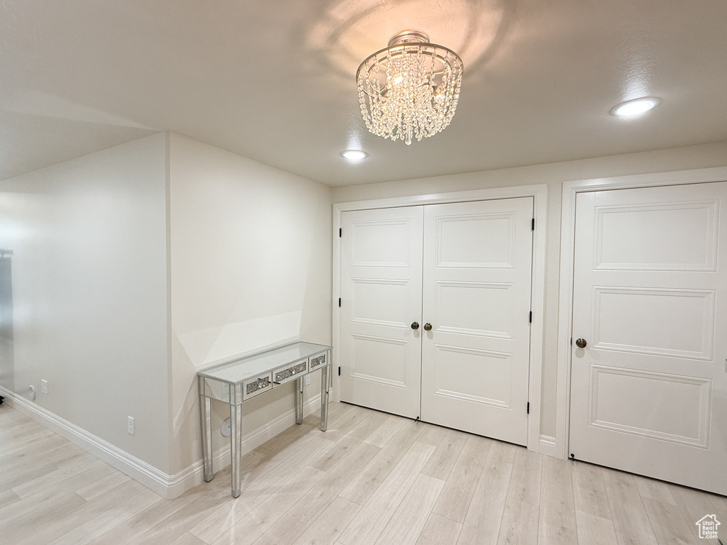 Entrance foyer with light wood-type flooring, a chandelier, recessed lighting, and baseboards