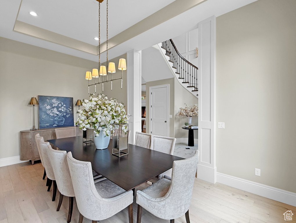Dining room featuring light wood-type flooring, baseboards, stairs, recessed lighting, and a chandelier