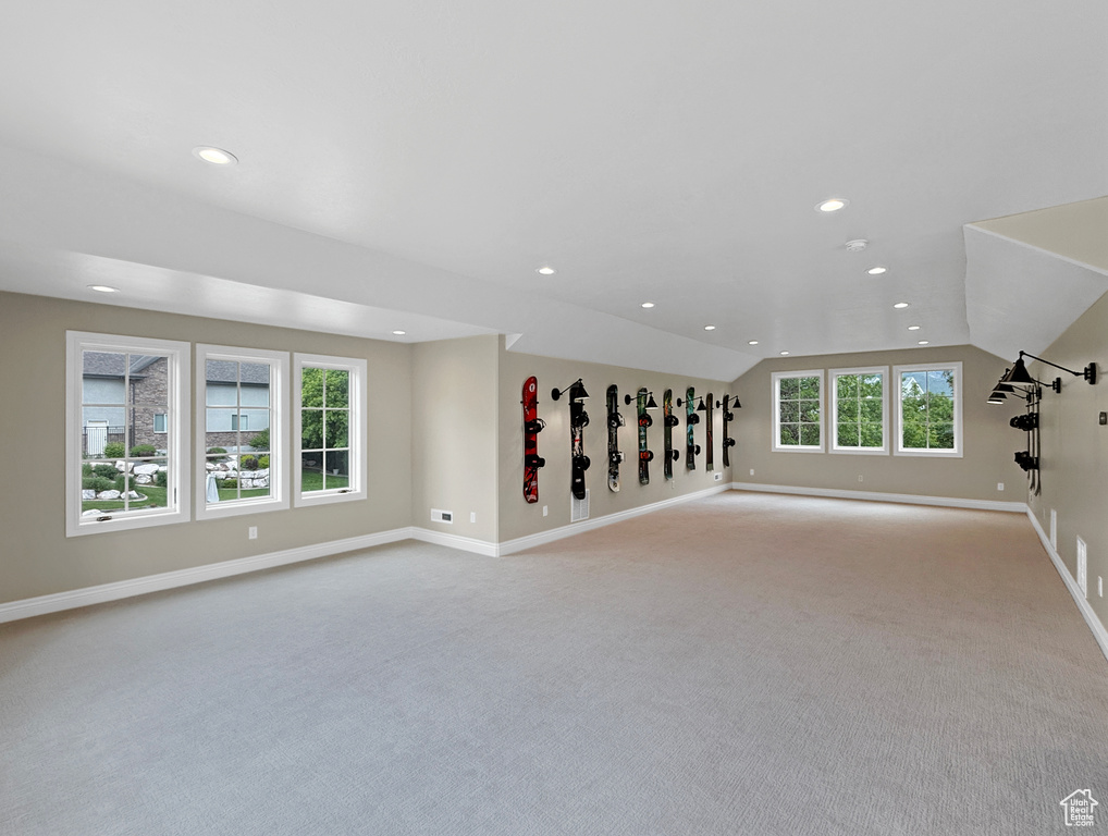 Unfurnished living room featuring carpet floors, vaulted ceiling, baseboards, and recessed lighting