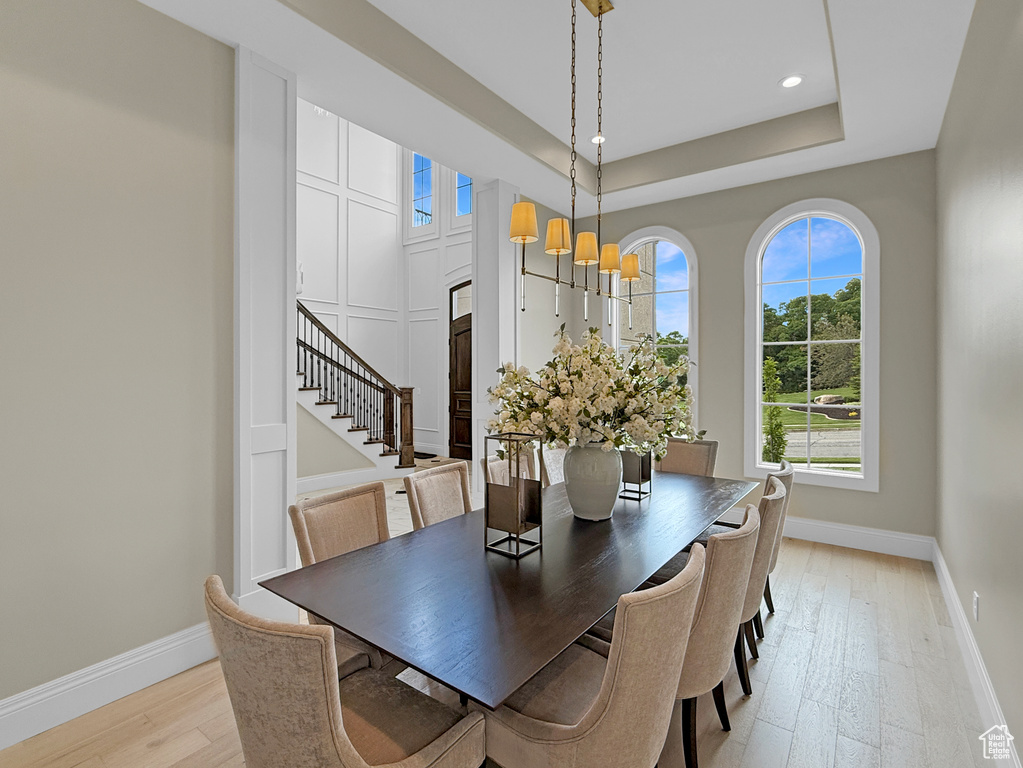 Dining area with baseboards, light wood-style floors, stairway, recessed lighting, and a chandelier