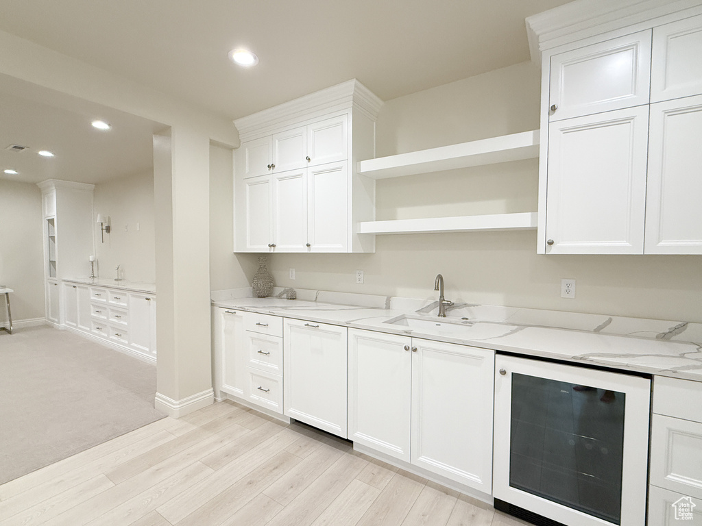 Kitchen with wine cooler, open shelves, light wood-type flooring, recessed lighting, and white cabinets