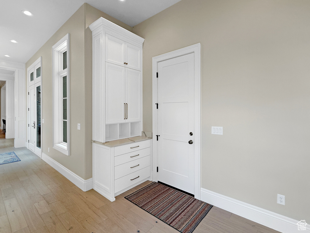 Foyer entrance featuring light wood-style floors, baseboards, and recessed lighting