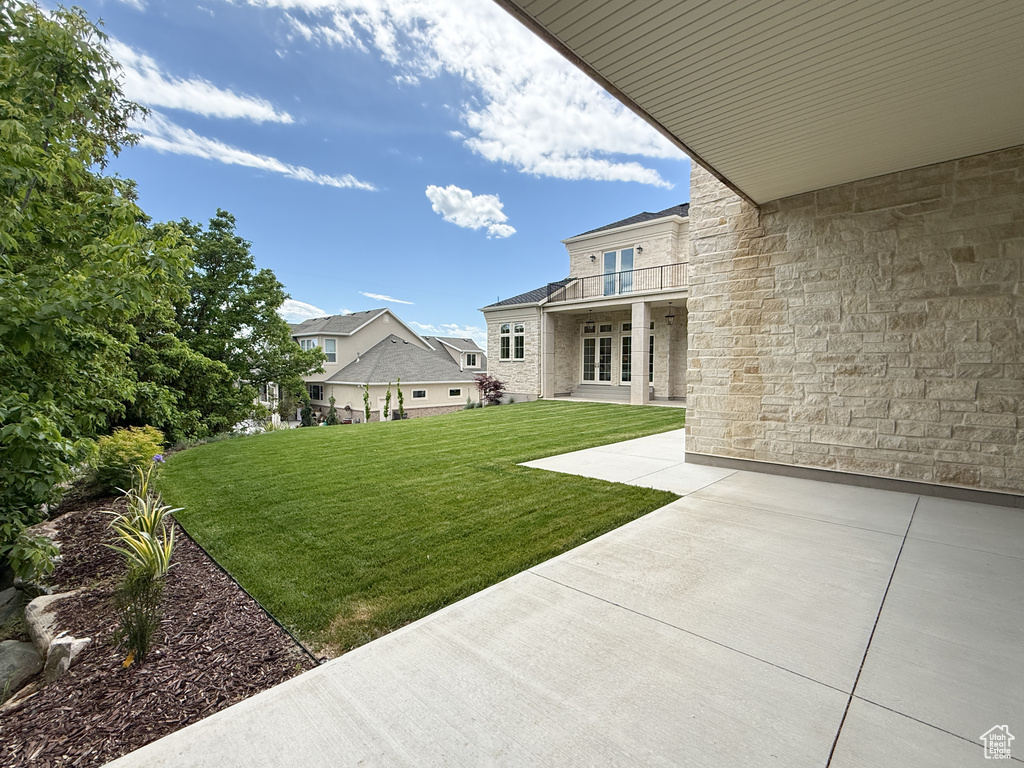 View of green lawn featuring a patio area and french doors