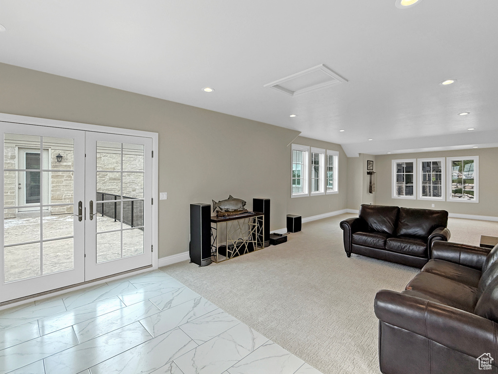 Living area with attic access, recessed lighting, french doors, marble look tile flooring, and baseboards