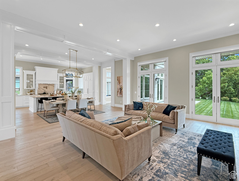 Living room featuring light wood-style floors, recessed lighting, ornamental molding, french doors, and baseboards