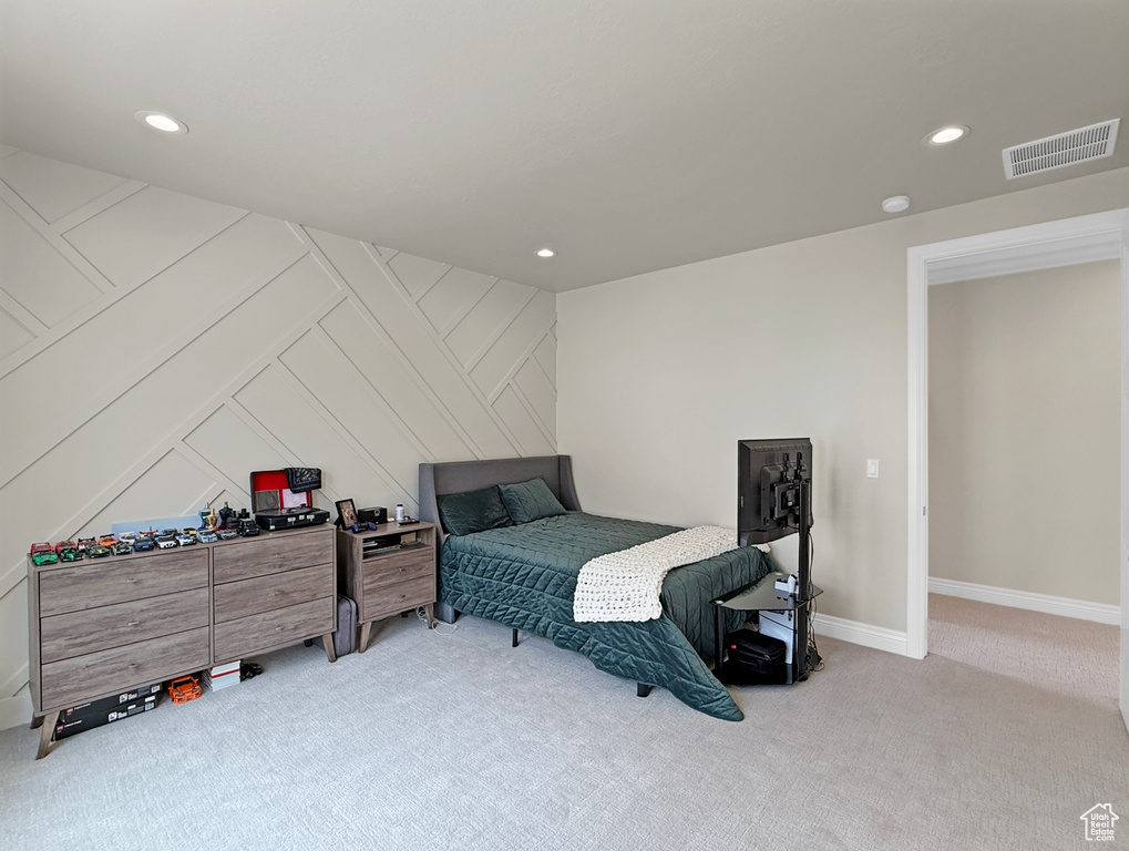 Bedroom with carpet flooring, recessed lighting, baseboards, and a decorative wall