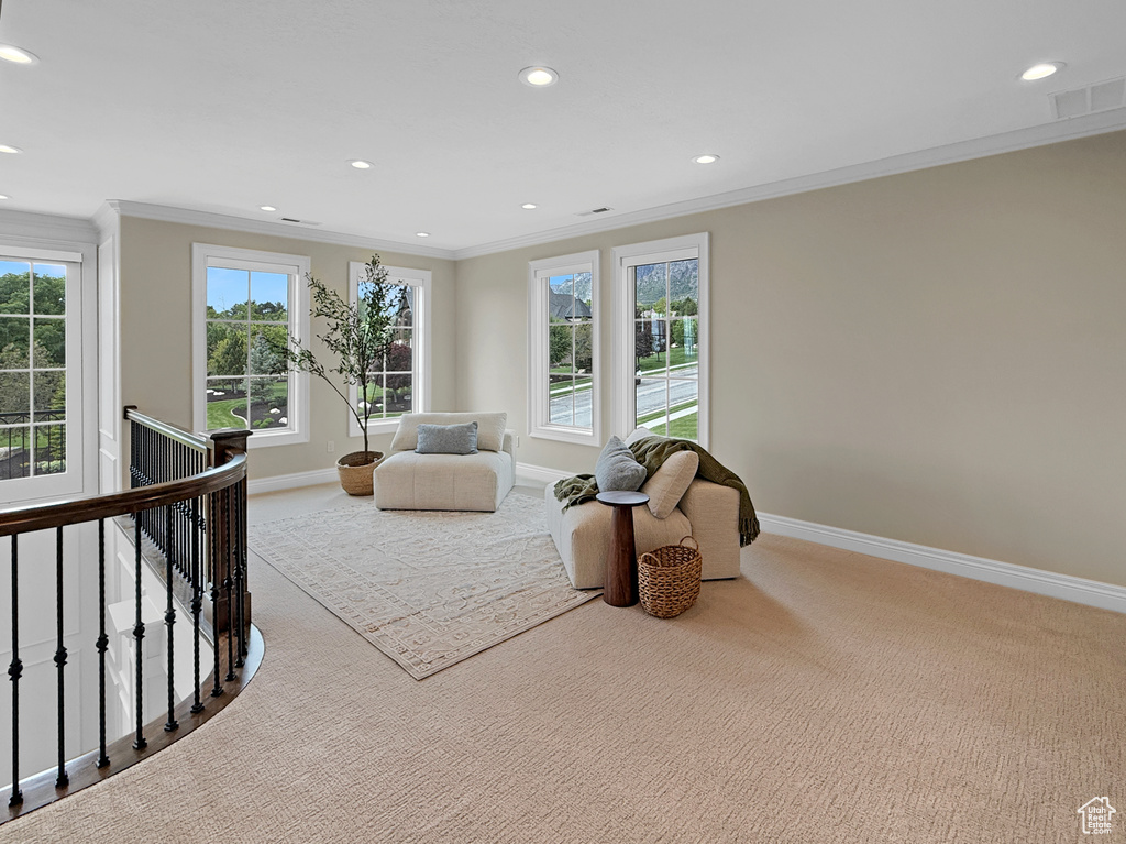 Sitting room with an upstairs landing, carpet floors, ornamental molding, baseboards, and recessed lighting