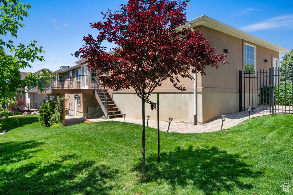 Rear view of house featuring stairway, a deck, and stucco siding