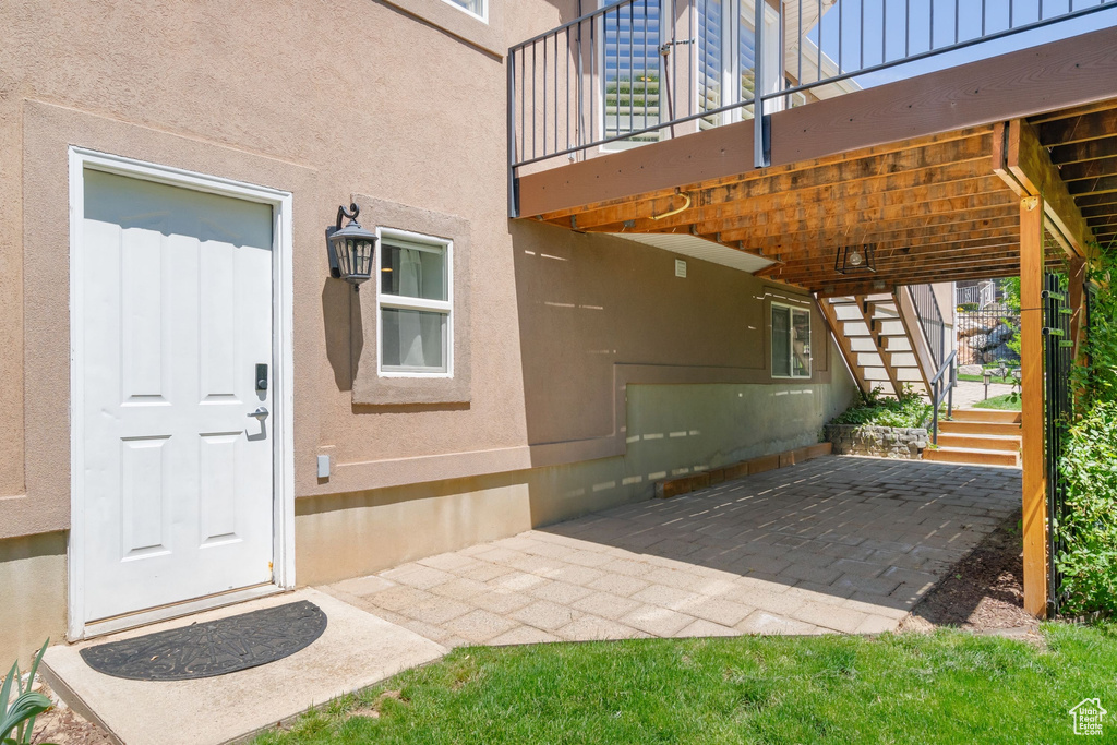 Property entrance with stucco siding and a patio area