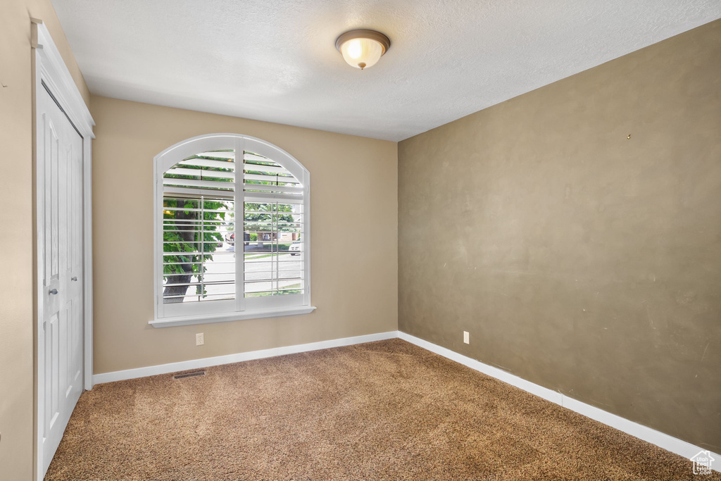 Carpeted empty room with baseboards
