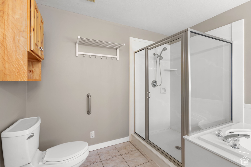 Full bath with toilet, a shower stall, tile patterned floors, and baseboards