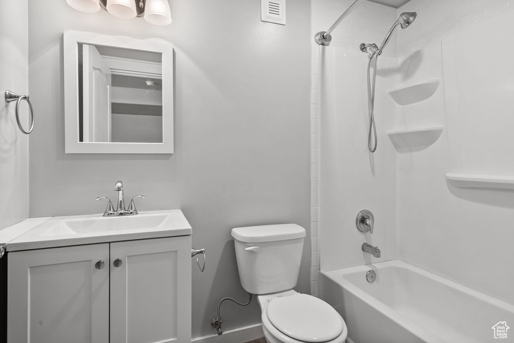 Bathroom with toilet, vanity, and shower / washtub combination