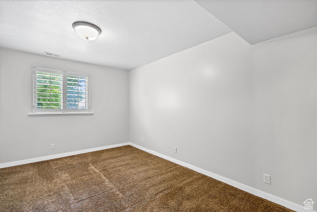 Spare room with baseboards and carpet flooring