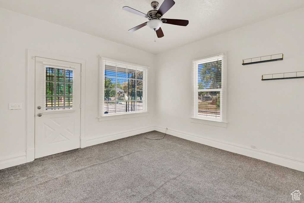 Unfurnished room with carpet flooring, a ceiling fan, and baseboards