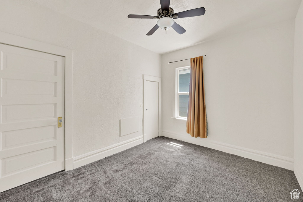 Spare room featuring carpet and a ceiling fan
