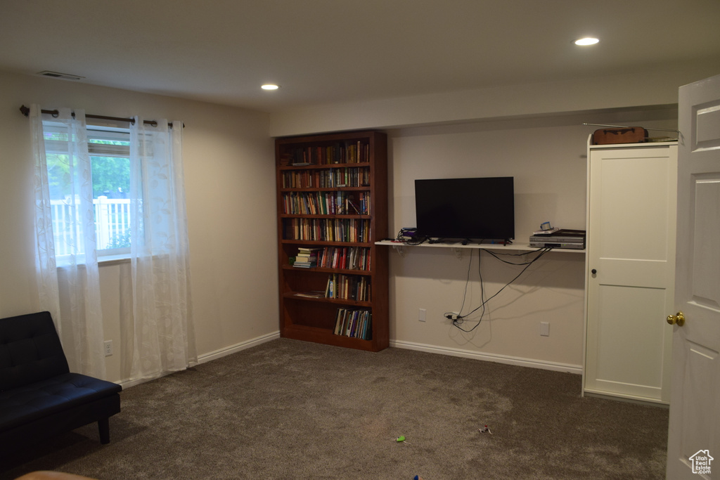 Living area with dark colored carpet, recessed lighting, and baseboards