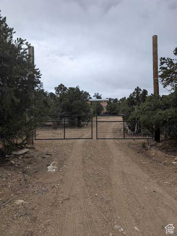 View of dirt / gravel road with a gate and a gated entry