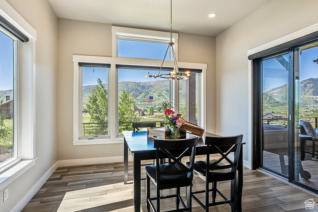 Dining room featuring a chandelier, dark wood-style floors, plenty of natural light, and recessed lighting