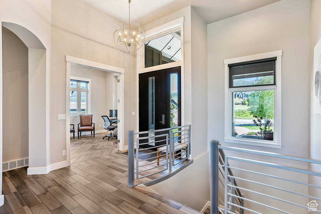 Foyer entrance with wood finished floors, baseboards, and a chandelier
