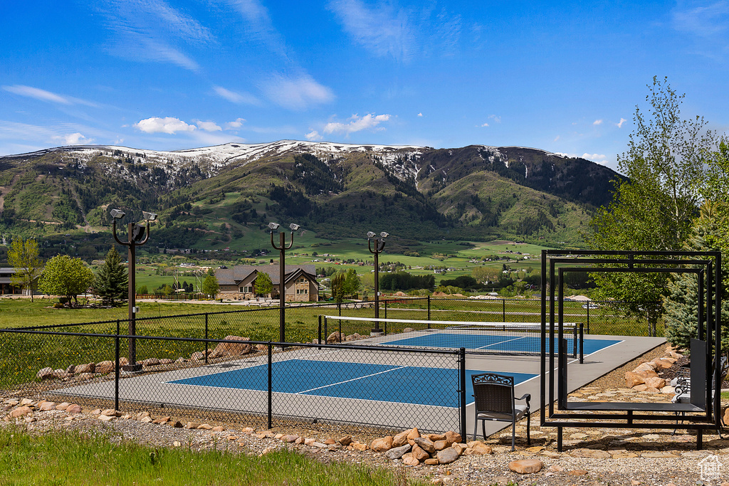View of pool with a tennis court and a mountain view
