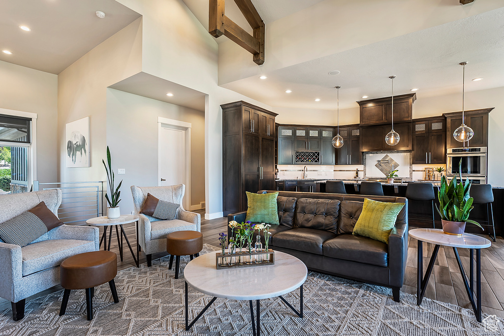Living area featuring a high ceiling, recessed lighting, dark wood finished floors, and baseboards