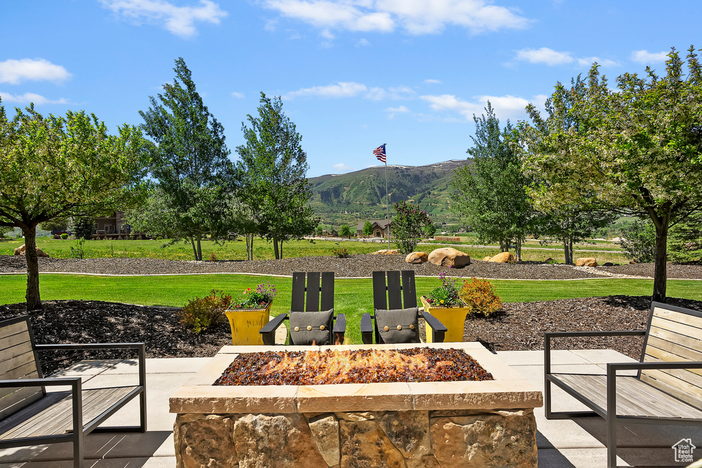View of patio with a fire pit and a mountain view
