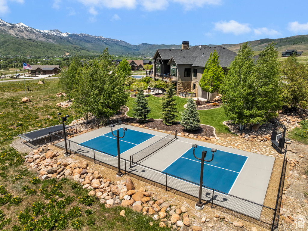 View of swimming pool with a tennis court and a mountain view