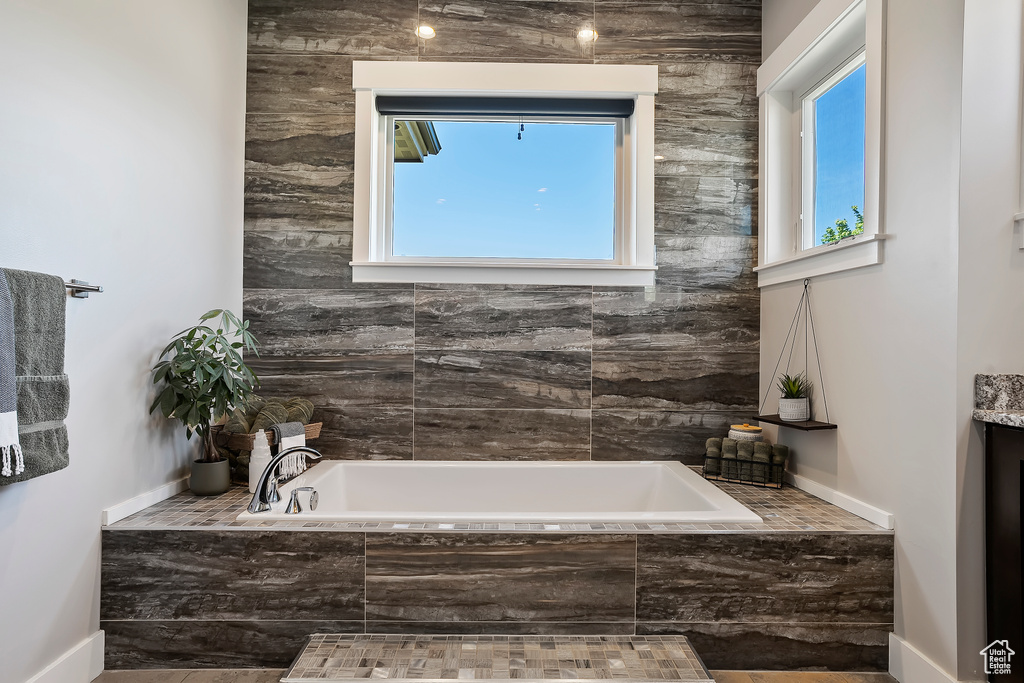 Full bath with a bath, vanity, and baseboards