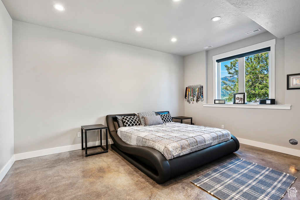 Bedroom featuring finished concrete flooring, recessed lighting, and baseboards