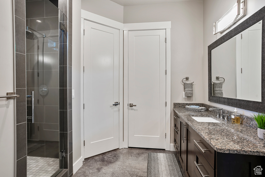 Full bath featuring a stall shower and vanity