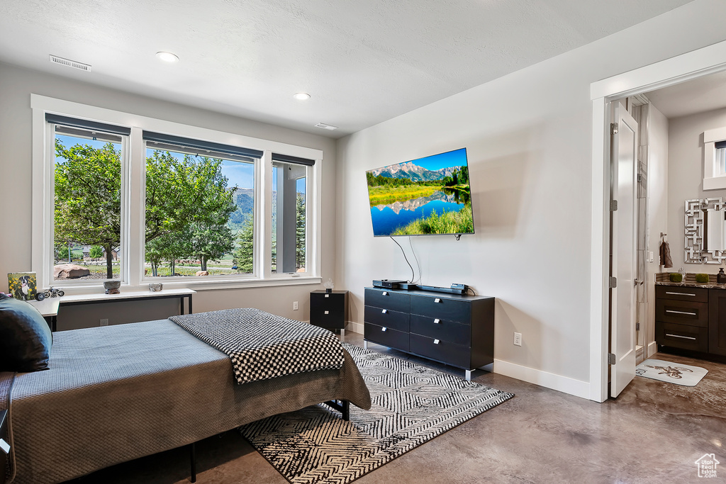 Bedroom featuring finished concrete floors, baseboards, and recessed lighting