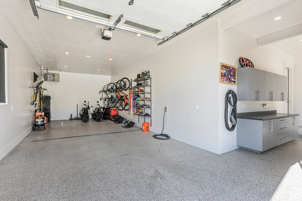 Garage featuring a garage door opener, baseboards, and recessed lighting