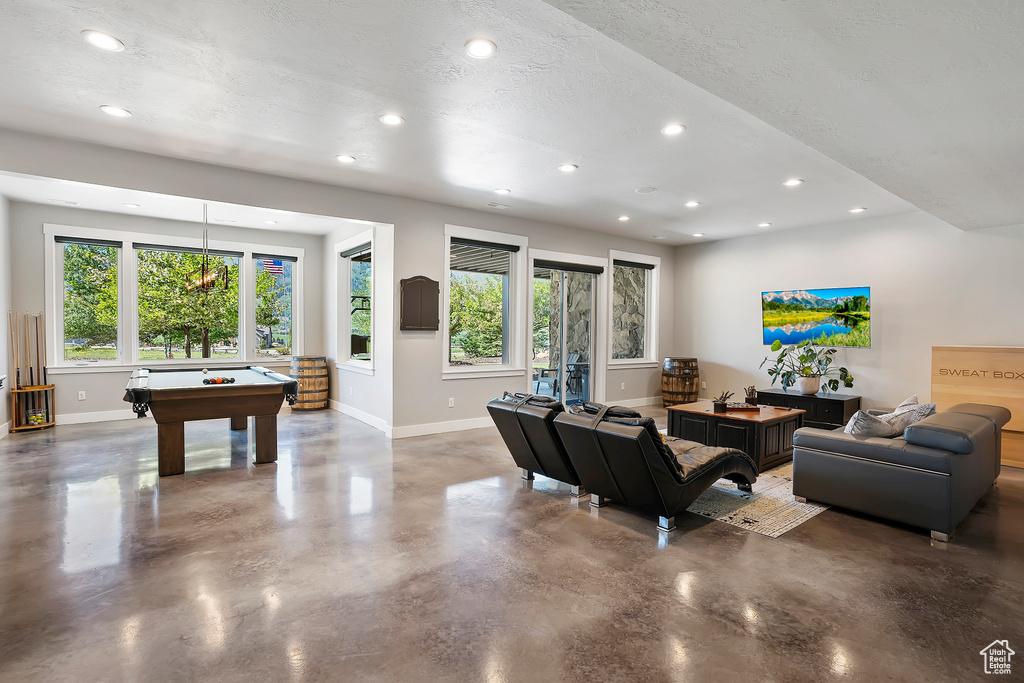 Living area with baseboards, concrete floors, pool table, recessed lighting, and a textured ceiling