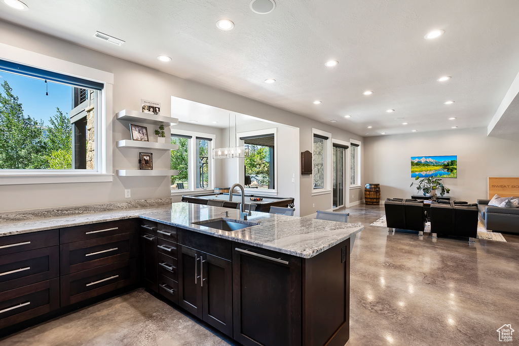 Kitchen with a sink, concrete floors, open floor plan, recessed lighting, and a peninsula