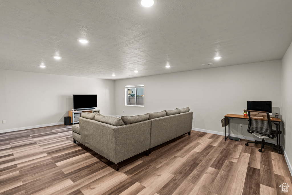 Living area featuring recessed lighting, wood finished floors, baseboards, and a desk