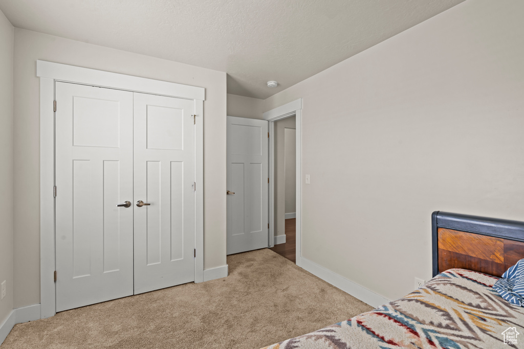 Carpeted bedroom featuring baseboards and a closet