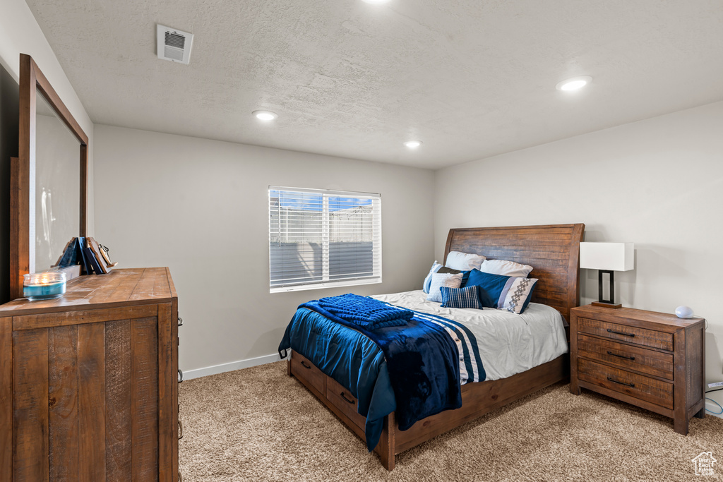 Bedroom with light carpet, recessed lighting, baseboards, and a textured ceiling