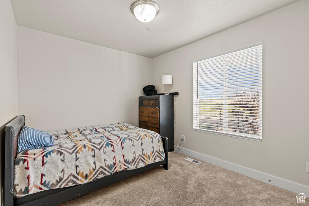 Bedroom featuring carpet and baseboards