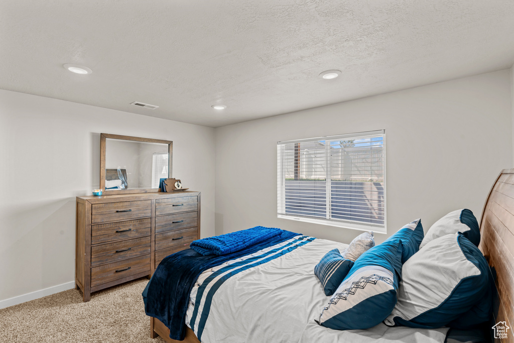 Bedroom with light carpet, baseboards, and recessed lighting