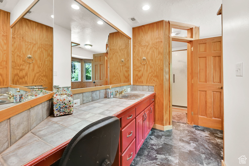 Bathroom with vanity, tasteful backsplash, and recessed lighting