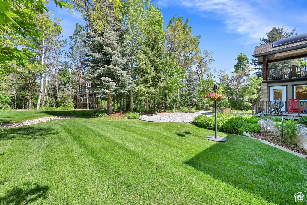 View of grassy yard with a balcony