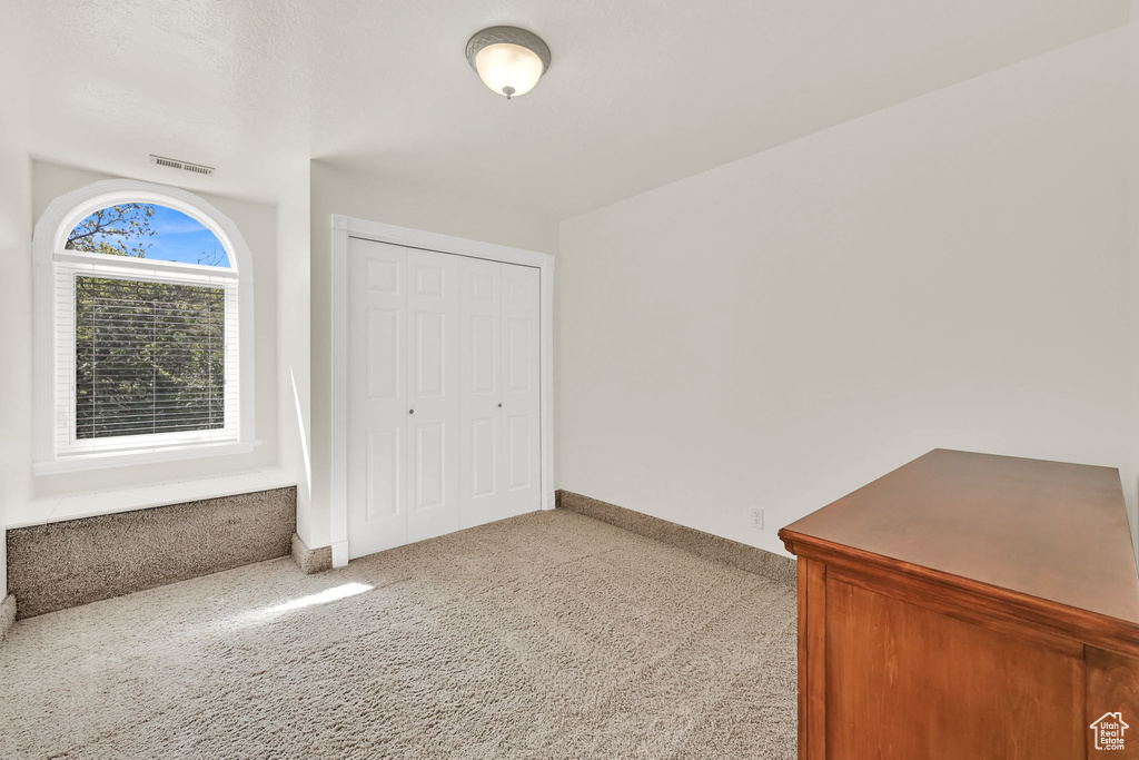 Unfurnished bedroom featuring carpet flooring, a closet, and baseboards