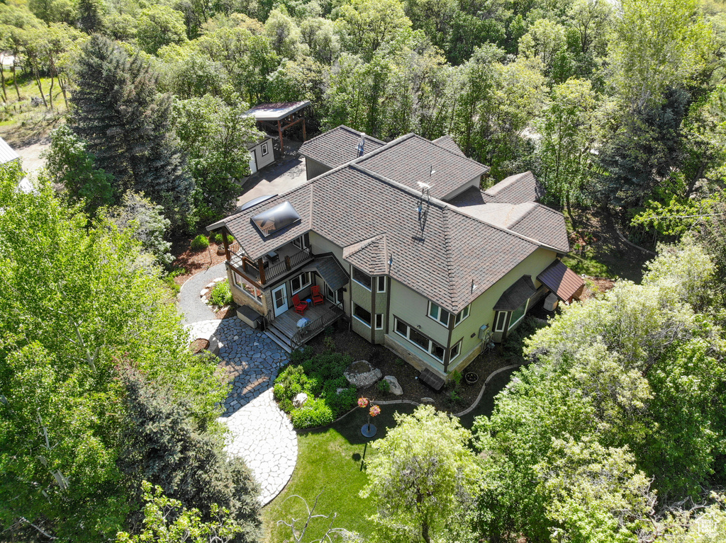 Aerial view of property and surrounding area featuring a forest