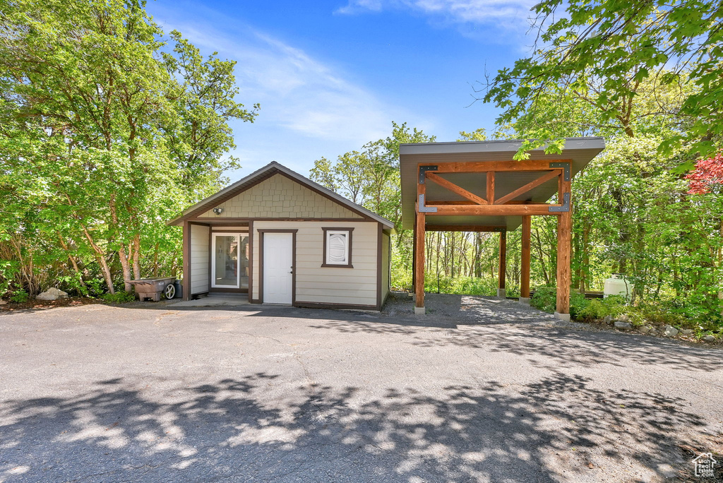View of front facade with an outdoor structure and driveway