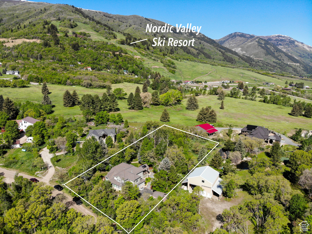 Aerial overview of property\'s location with property boundaries highlighted and a mountainous background