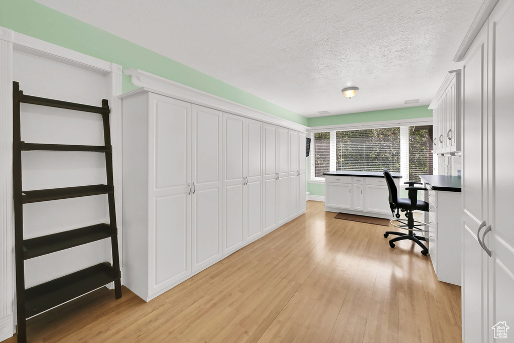 Home office featuring a textured ceiling and light wood-style flooring