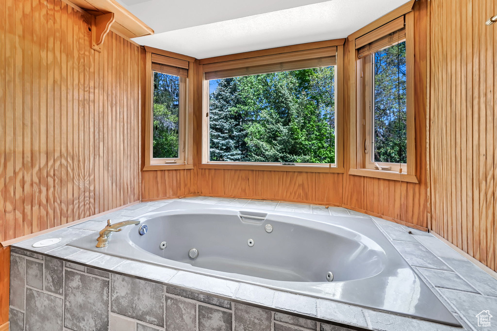 Full bath with a whirlpool tub and wooden walls