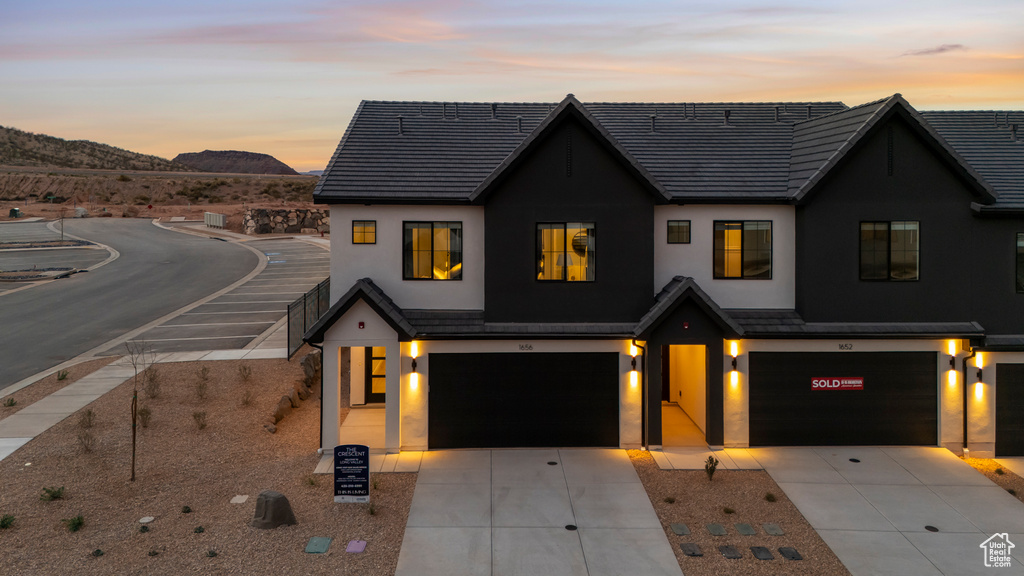 View of front of property featuring a garage, stucco siding, and a mountain view